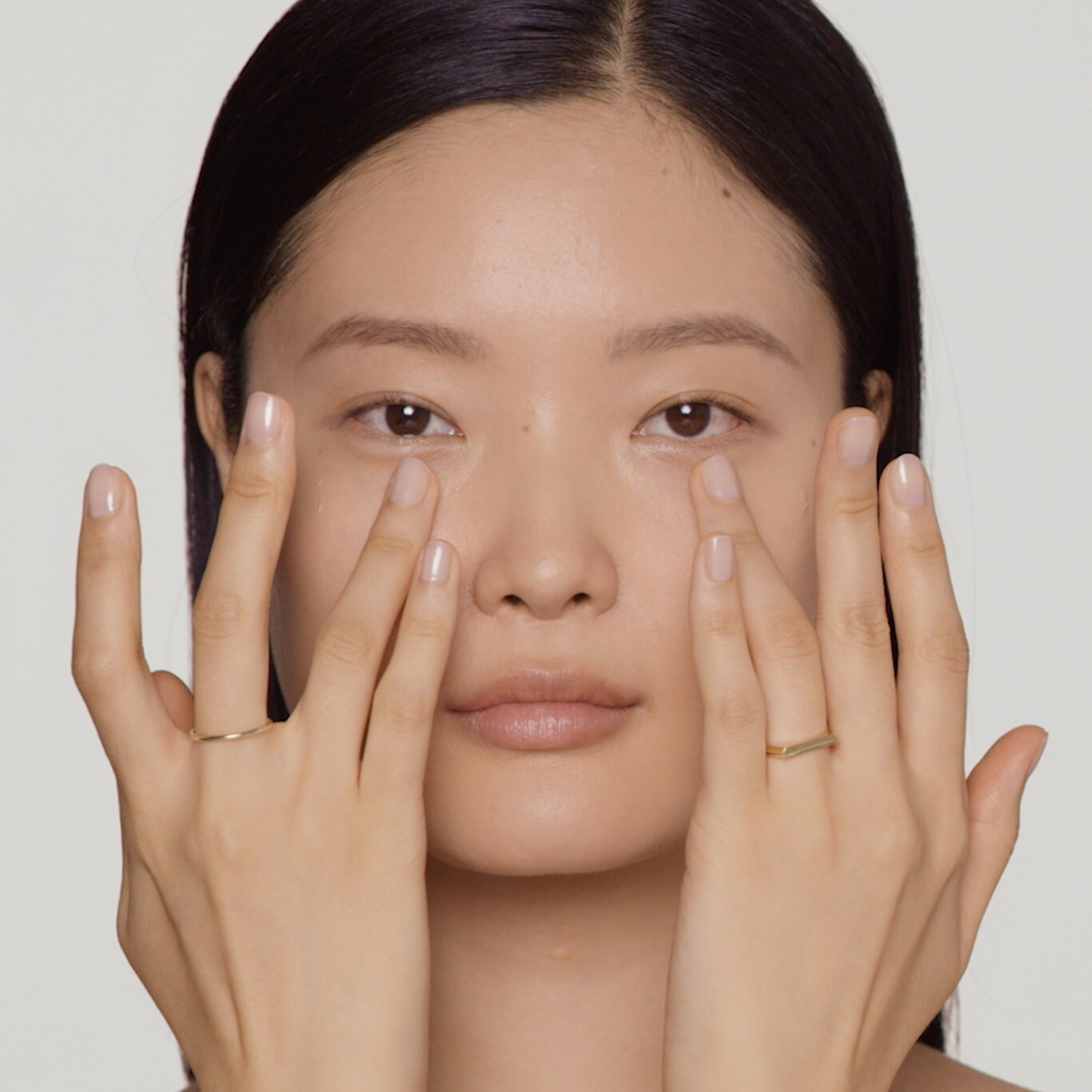Model applies gel-creme to inner corner of eyes