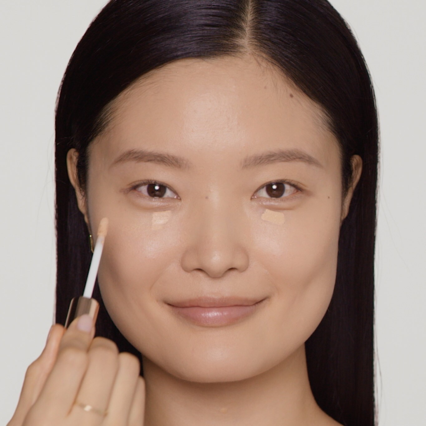 Model applies gel-creme to outer corner of eyes